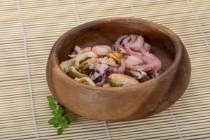 Seafood cocktail in a bowl on wooden background photo