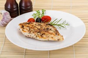 Grilled chichen breast on the plate and wooden background photo