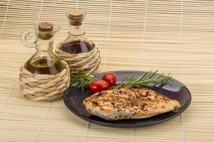 Grilled chichen breast on the plate and wooden background photo