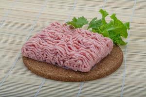 Raw minced pork meat on wooden board and wooden background photo