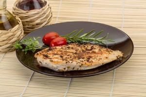 Grilled chichen breast on the plate and wooden background photo