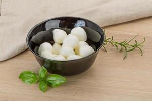 Mozzarella cheese in a bowl on wooden background photo