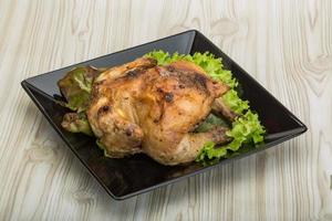 Roasted chicken on the plate and wooden background photo