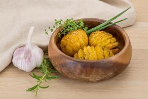 Baked potato in a bowl on wooden background photo