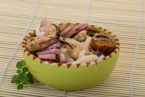 Seafood cocktail in a bowl on wooden background photo