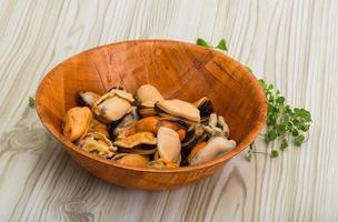 Mussels in a bowl on wooden background photo