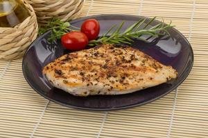 Grilled chichen breast on the plate and wooden background photo