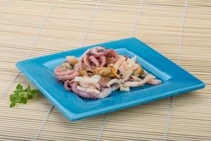 Seafood cocktail on the plate and wooden background photo