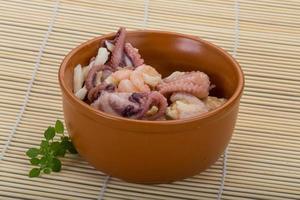 Seafood cocktail in a bowl on wooden background photo