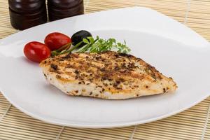 Grilled chichen breast on the plate and wooden background photo