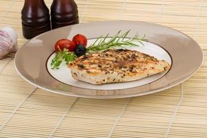 Grilled chichen breast on the plate and wooden background photo