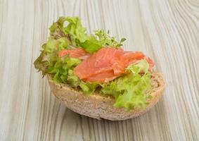 sándwich de salmón con tomillo sobre fondo de madera foto