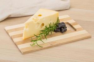 queso maasdam sobre tablero de madera y fondo de madera foto