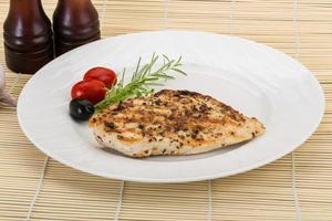 Grilled chichen breast on the plate and wooden background photo