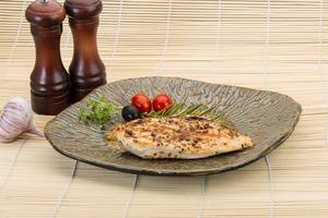 Grilled chichen breast on the plate and wooden background photo