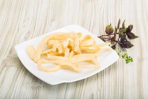 calamares secos en el plato y fondo de madera foto