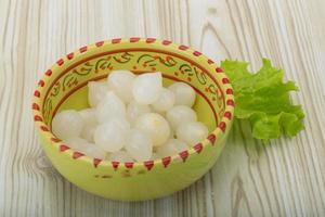 Marinated onion in a bowl on wooden background photo