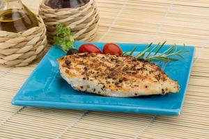 Grilled chichen breast on the plate and wooden background photo