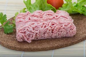 Raw minced pork meat on wooden board and wooden background photo