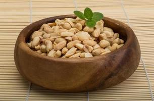 Peanut in a bowl on wooden background photo