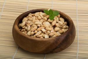Peanut in a bowl on wooden background photo