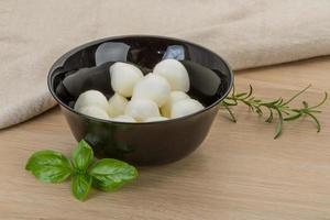 Mozzarella cheese in a bowl on wooden background photo