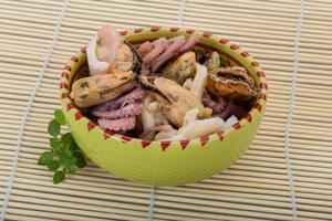 Seafood cocktail in a bowl on wooden background photo