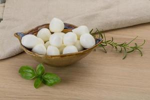 queso mozzarella en un bol sobre fondo de madera foto