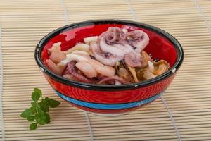 Seafood cocktail in a bowl on wooden background photo