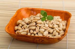 Peanut in a bowl on wooden background photo