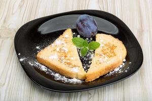 Sweet french toast on the plate and wooden background photo