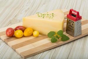 Parmesan cheese on wooden board and wooden background photo