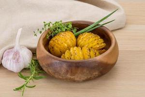 Baked potato in a bowl on wooden background photo