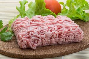 Raw minced pork meat on wooden board and wooden background photo