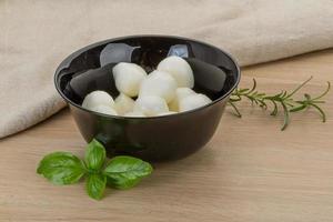 Mozzarella cheese in a bowl on wooden background photo