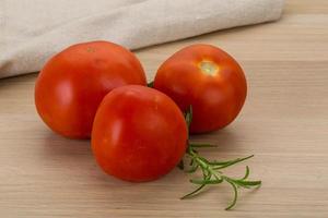 Fresh tomatoes on wooden background photo