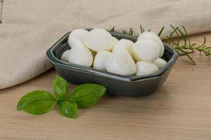 Mozzarella cheese in a bowl on wooden background photo