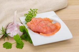 Sliced salmon in a bowl on wooden background photo