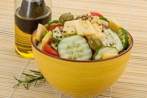 Greek salad in a bowl on wooden background photo