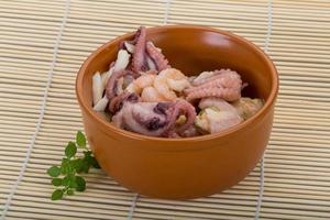 Seafood cocktail in a bowl on wooden background photo