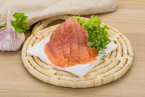 Sliced salmon on wooden board and wooden background photo