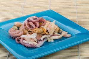 Seafood cocktail on the plate and wooden background photo