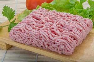 Raw minced pork meat on wooden board and wooden background photo