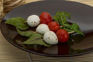 ensalada caprese en el plato y fondo de madera foto