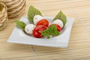 ensalada caprese en el plato y fondo de madera foto