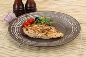 Grilled chichen breast on the plate and wooden background photo