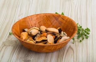 Mussels in a bowl on wooden background photo