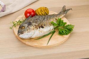 Grilled dorado on wooden board and wooden background photo