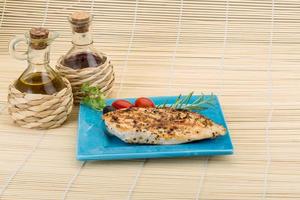 Grilled chichen breast on the plate and wooden background photo