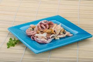 Seafood cocktail on the plate and wooden background photo